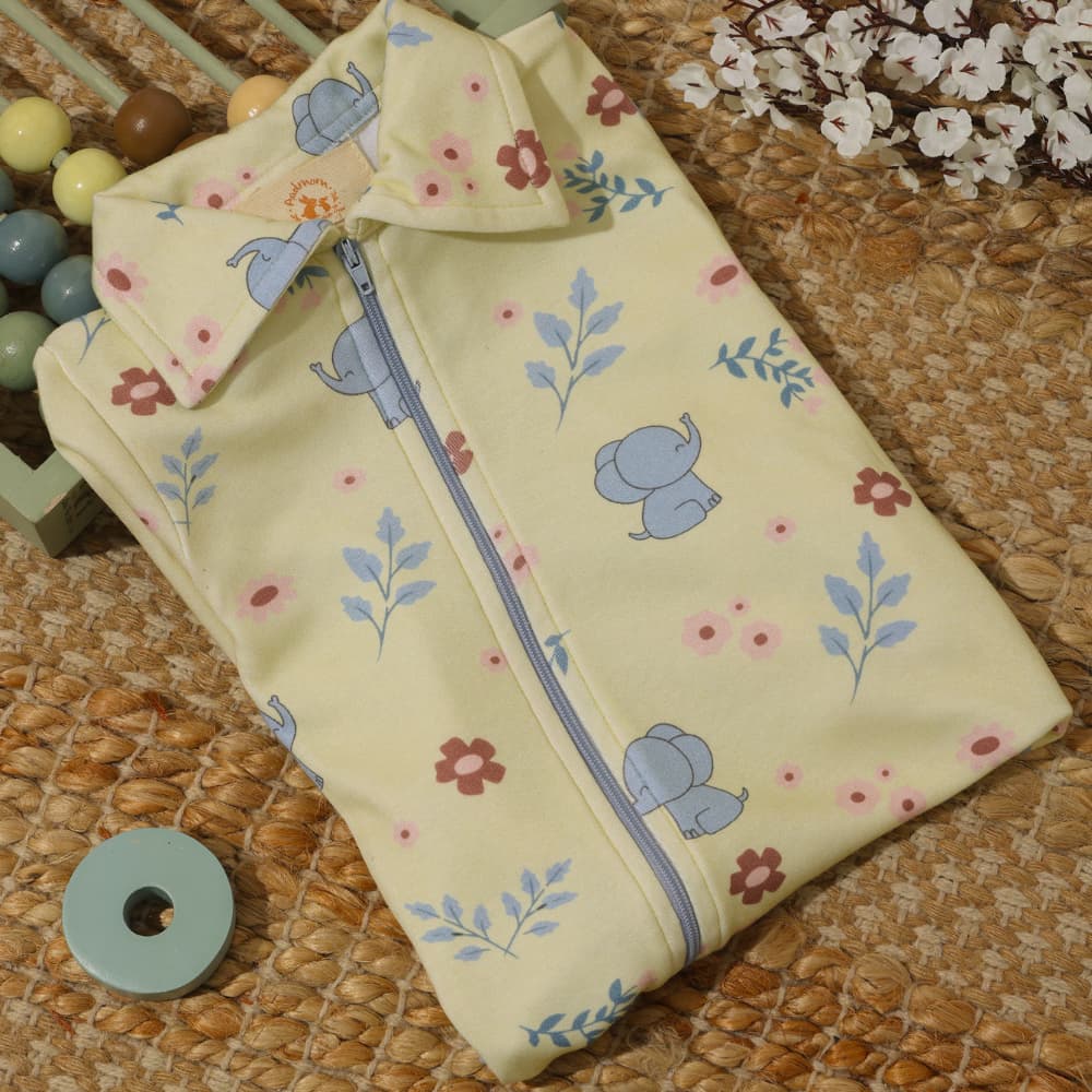 Baby bodysuit with elephant Tusker print, snap closures at bottom.